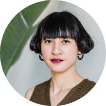 Woman with blunt bangs and hoop earrings