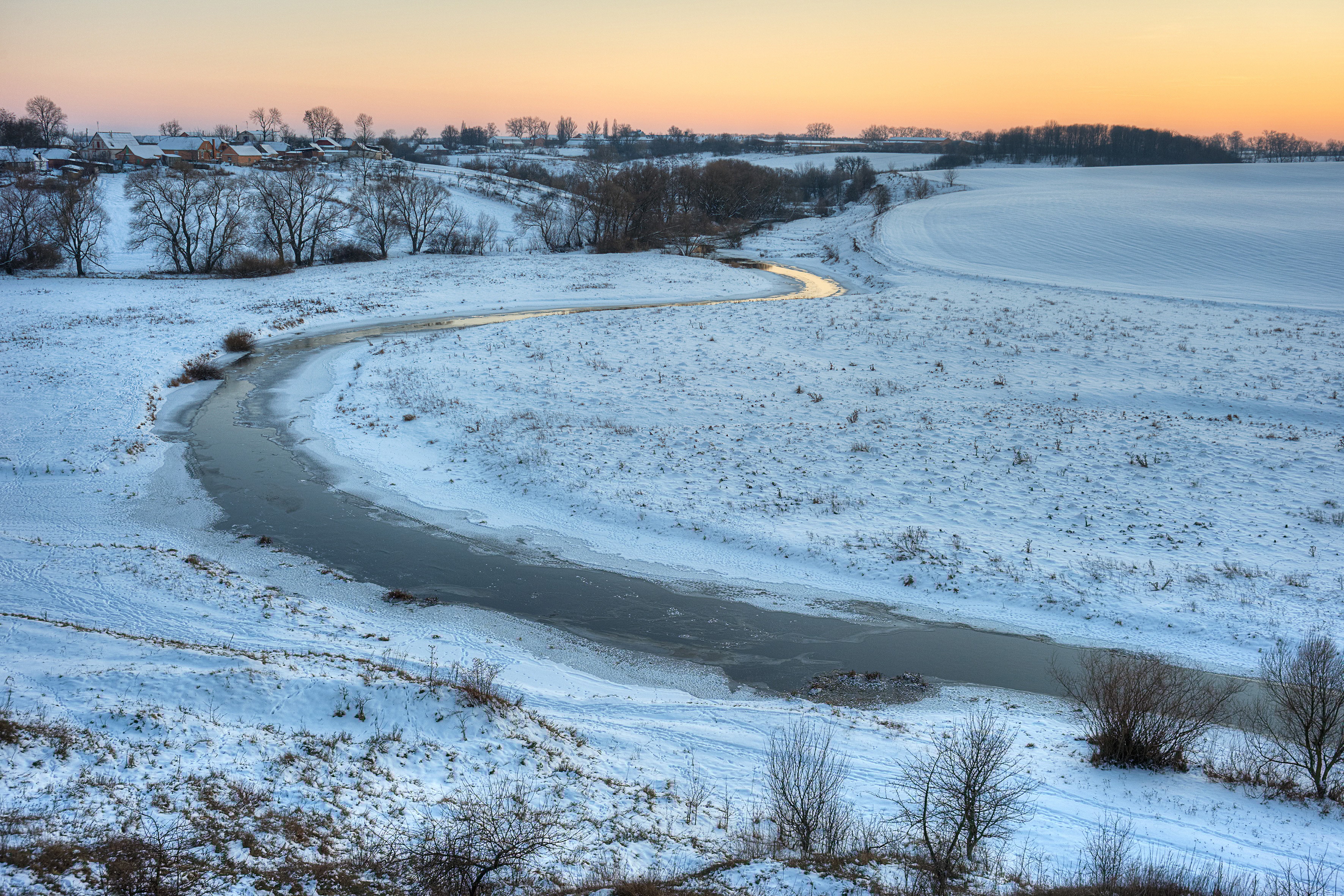 Snowy field with stream in the Winter