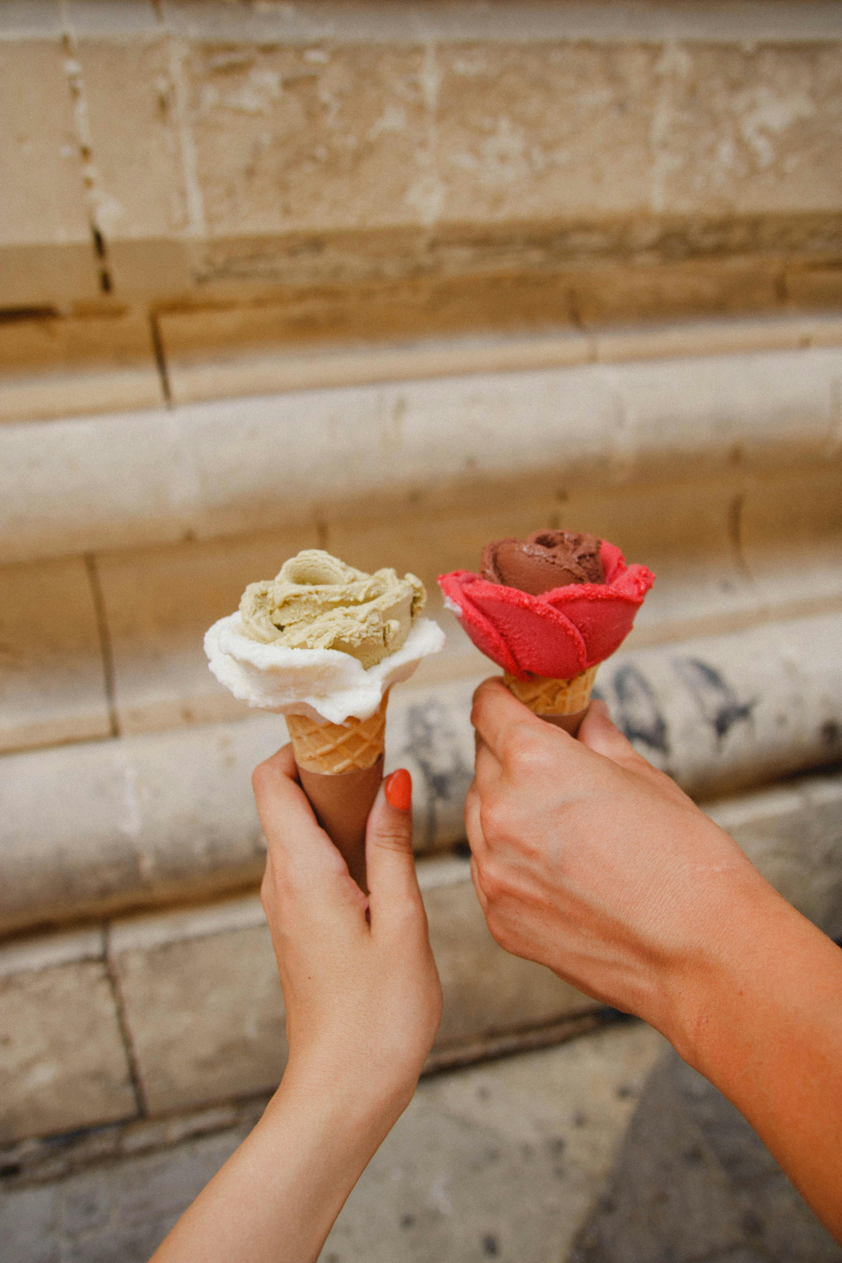 Two people holding icecream cones.